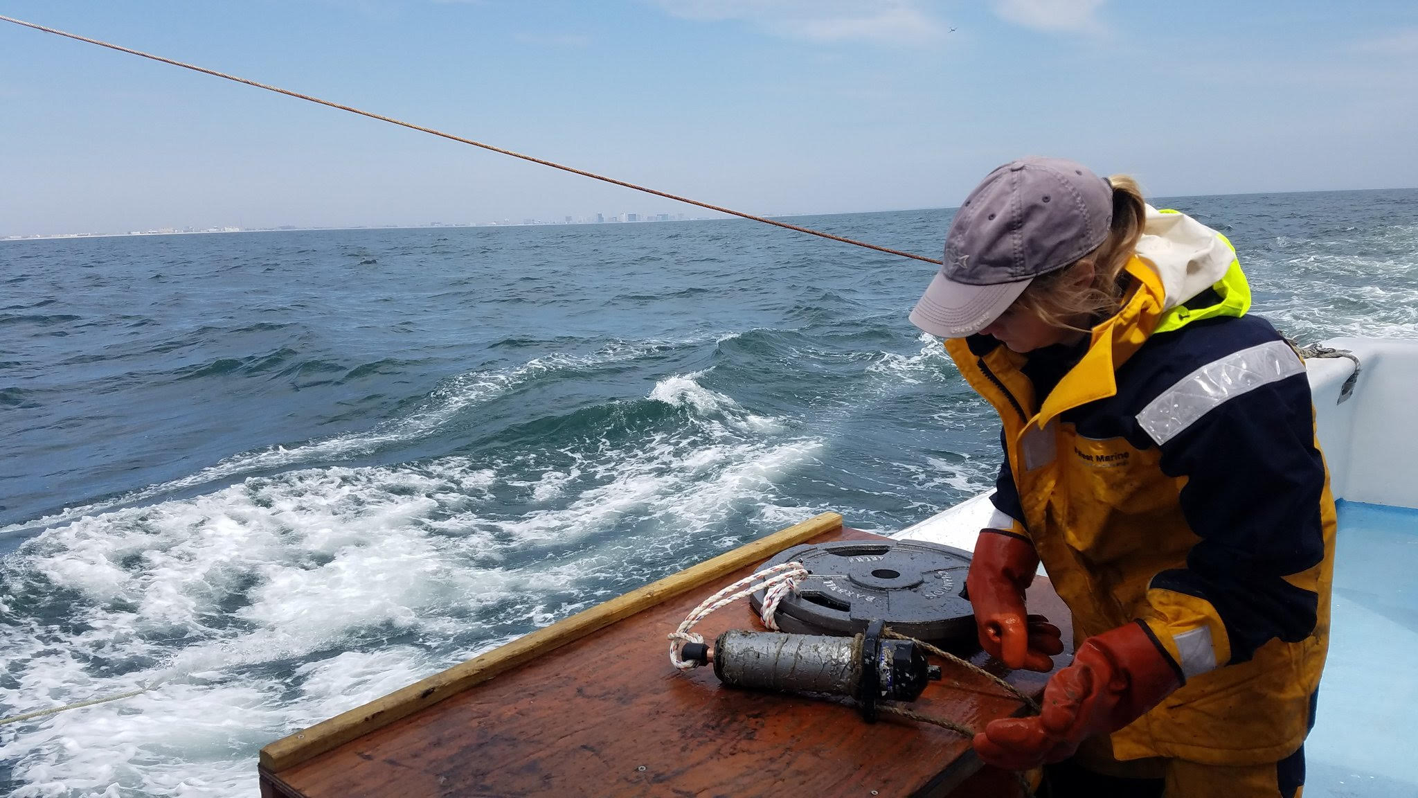 Ellie Rothermel configures acoustic reciever off coast of Ocean City, Maryland.