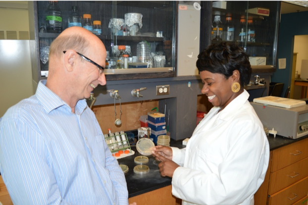 Dr. Jeanette Davis showing a sample to Dr. Russell Hill in their lab