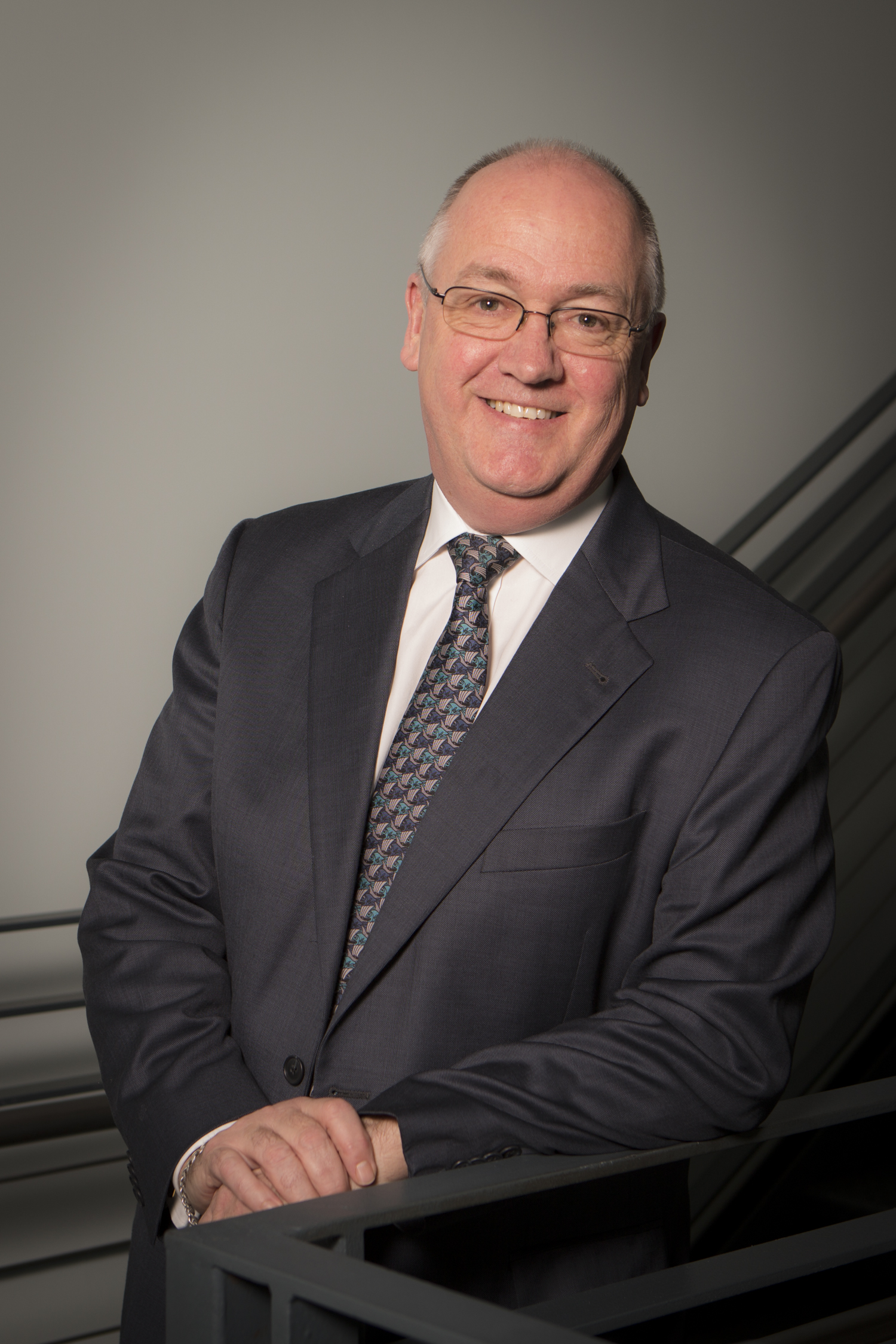 Dr. Tom Miller dressed in a dark suit and tie