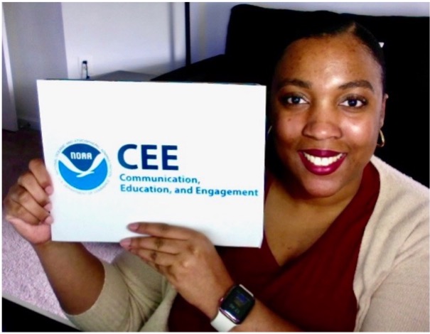 Shadaesha Green holds a sign that says NOAA CEE