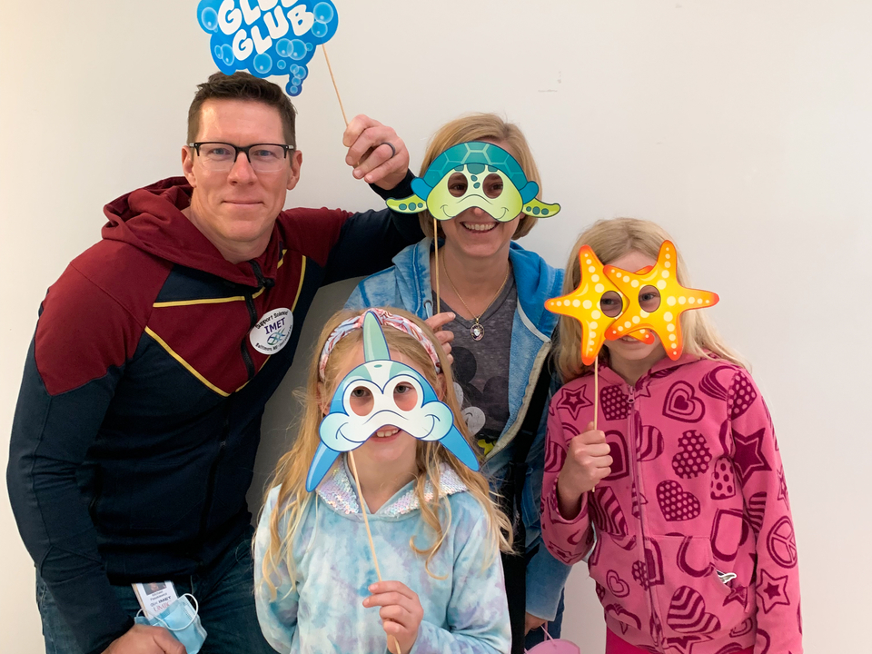 A family at IMET's open house has fun with our sea life face masks