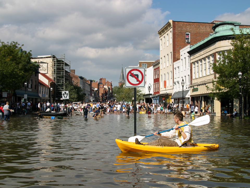 Annapolis flooded, a person kayaks in the street.