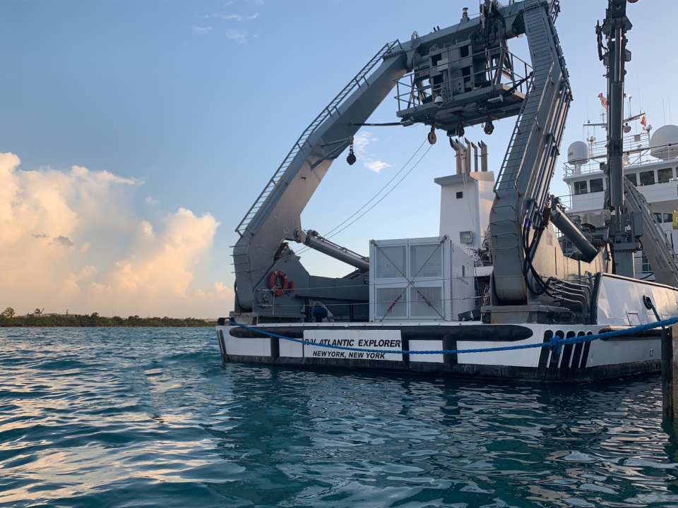 The back end of the Atlantic Explorer research vessel surrounded by blue waters.