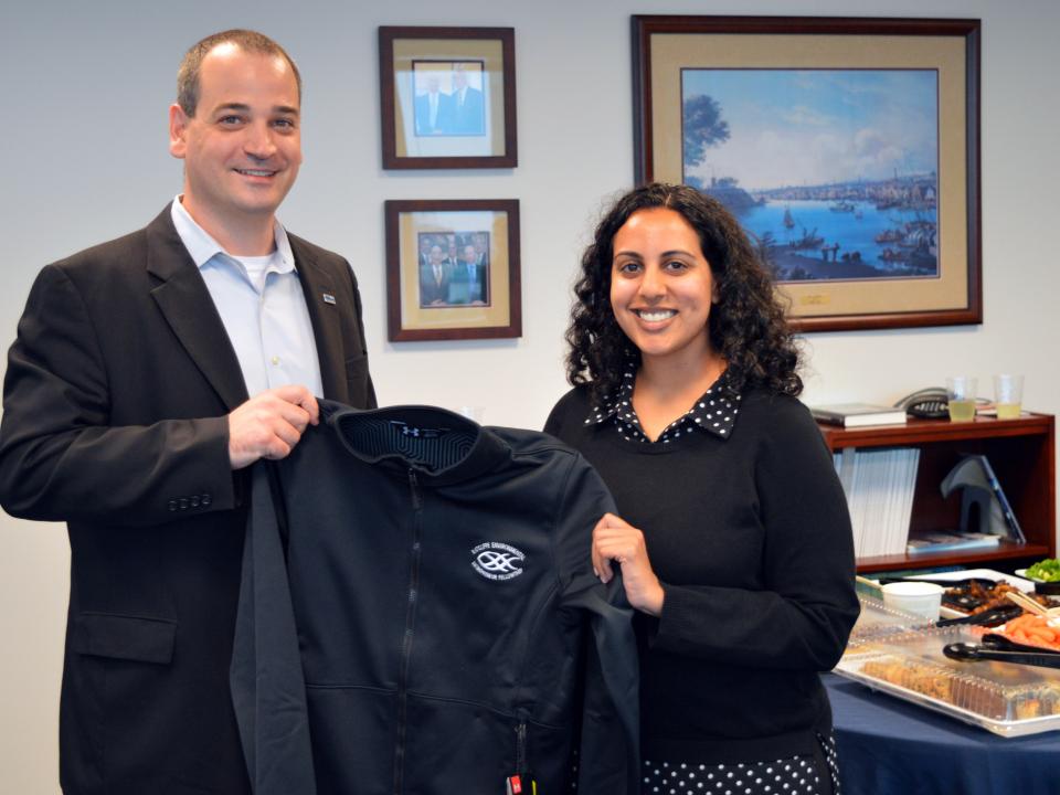 Saddef Haq receives her REEF jacket from Nicholas Hammond. 