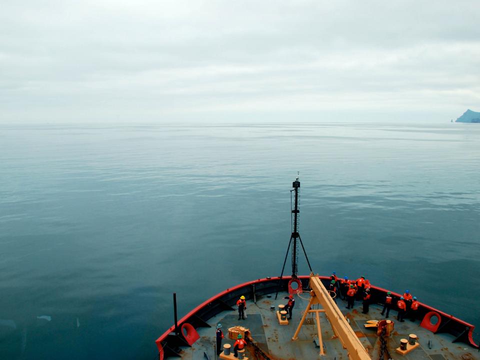 USCGC Healy peeks into frame as it cruises through Arctic waters.