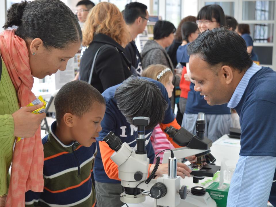 Family talking to scientist at IMET Open House event