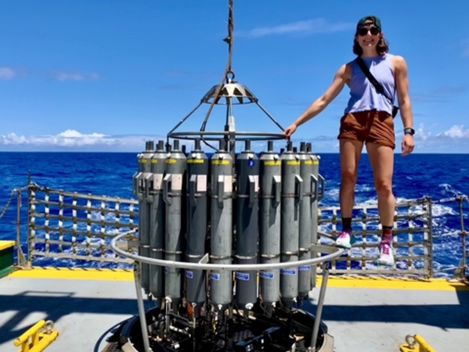 Maddy Lahm stands on top of at CTE, a piece of scientific equipment, on a research vessel