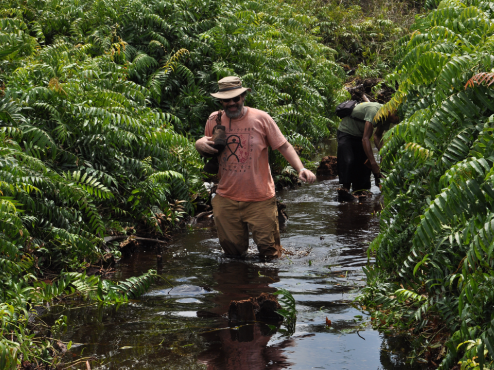 Mark Cochrane hikes through water in Indonesia.