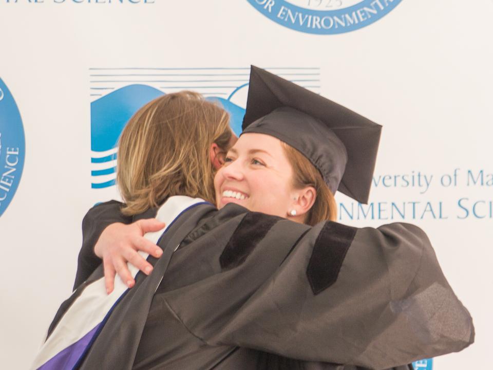 Lora Harris hugs her student, Jessica Foley, who earned her master's degree.