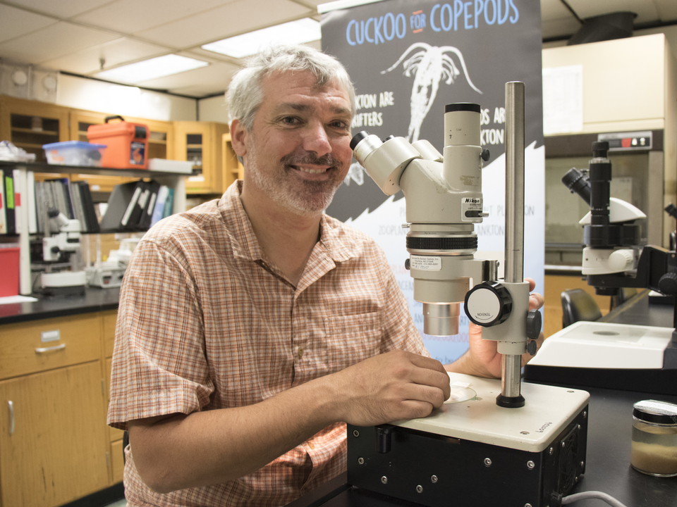 Jamie Pierson in his laboratory with a microscope