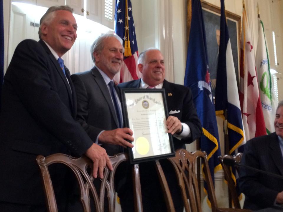 Gov. Larry Hogan presents UMCES President Don Boesch with a Maryland governor's citation while Virginia Gov. Terry McAuliffe (far left) looks on. 