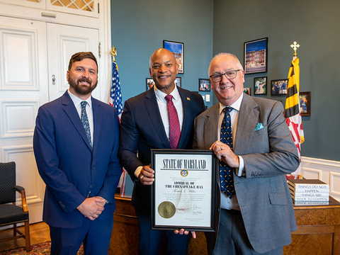 Maryland DNR Secretary Josh Kurtz and Governor Wes Moore present Professor Thomas Miller with the ‘Admiral of the Chesapeake Bay’ Award.