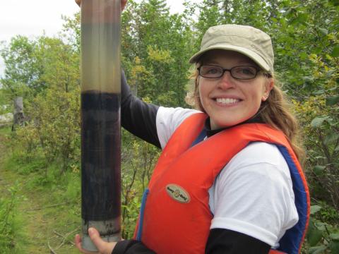 Grad student Hadley McIntosh holds up a soil sample in the field.