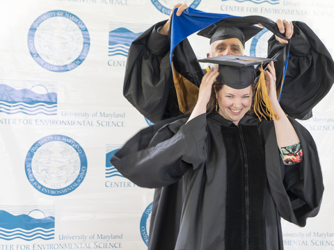 A graduate gets hooded at our 2022 Commencement