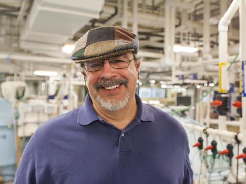 Scientist Al Place poses inside his lab's aquaculture facility.