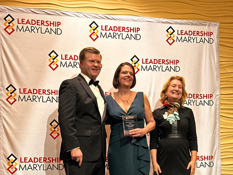 Dr. Carys Mitchelmore in the center. A man and woman representing Leadership Maryland are at her sides.