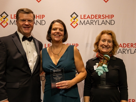 Dr. Carys Mitchelmore in the center. A man and woman representing Leadership Maryland are at her sides.