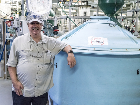 Al Place Stands next to an aquaculture tank at IMET