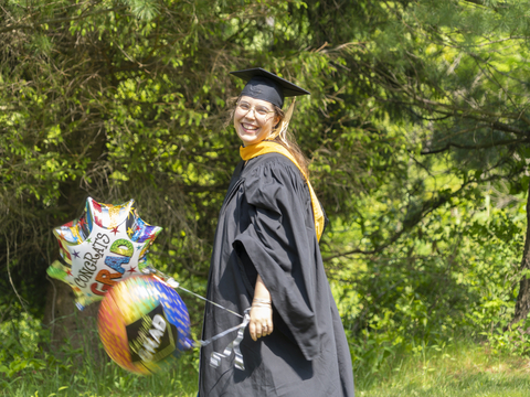 Graduate student holding a balloon