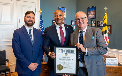 Maryland DNR Secretary Josh Kurtz and Governor Wes Moore present Professor Thomas Miller with the ‘Admiral of the Chesapeake Bay’ Award.