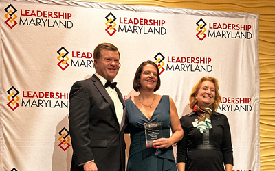 Dr. Carys Mitchelmore in the center. A man and woman representing Leadership Maryland are at her sides.
