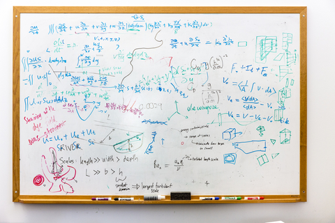 Whiteboard with science formulas written across it.