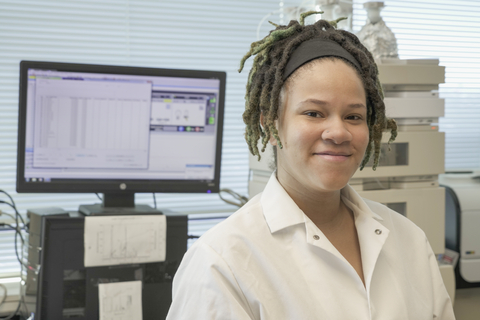 Anya Byrd in a lab coat in front of a computer