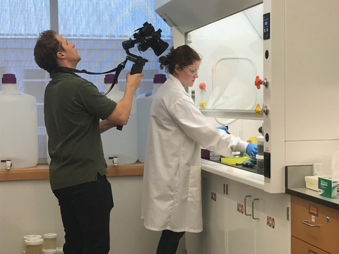 A CBL student works in the lab with a camera over her shoulder