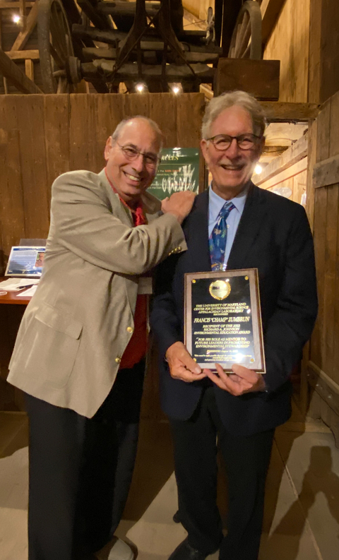 Steve Resh, nominator, and Francis "Champ" Zumbrun standing in barn with award. 