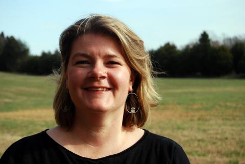 headshot of lora harris  in a green field