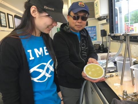 Graduate student Menqi Sun and Professor Feng Chen filter bacteria aboard the R/V Rachel Carson ship.