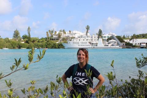 Science Communicator Emily Ramirez with Atlantic Explorer research vessel and Bermuda in background.