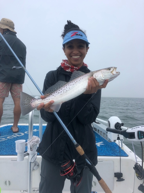 Samara holding a a fish on a boat