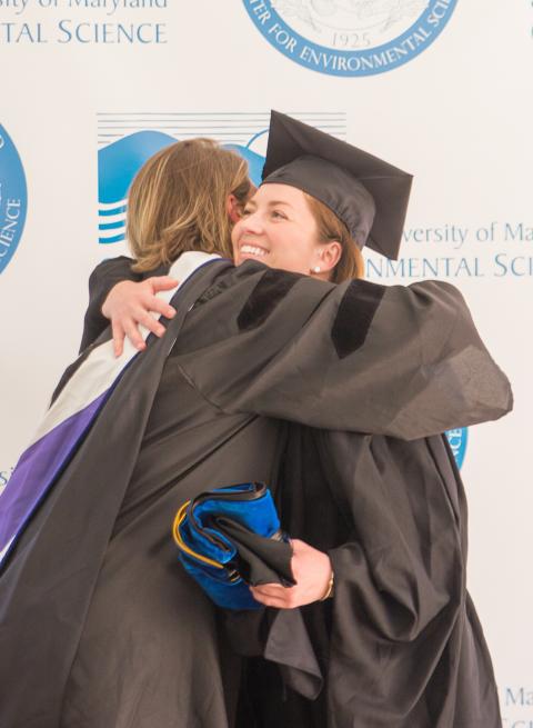 Lora Harris hugs her student, Jessica Foley, who earned her master's degree.