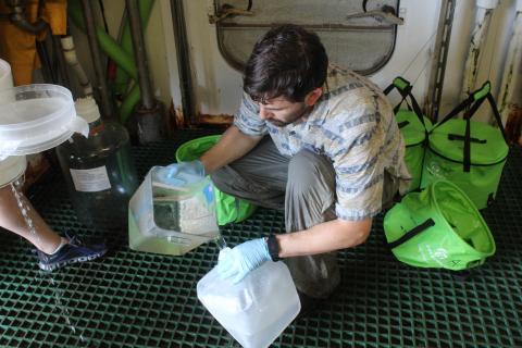 Microbial ecologist Jacob Cram filtering water on board a research ship.