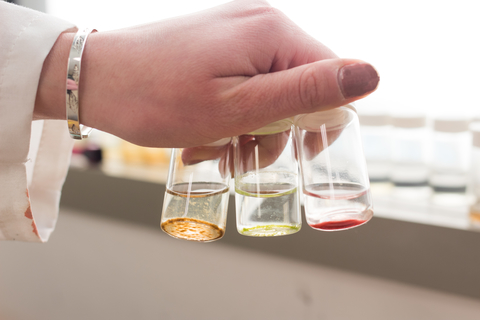 Lauren Jonas holding vials with colorful bacteria extracted from marine sponges