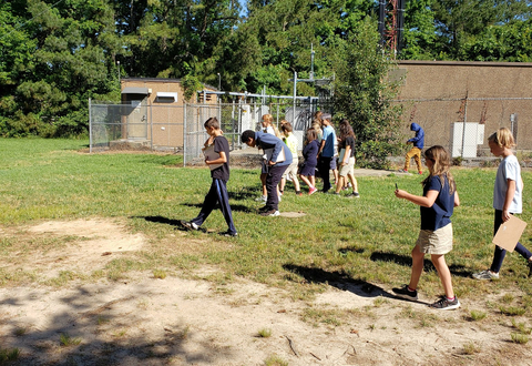 Students survey plastic waste on their school grounds.