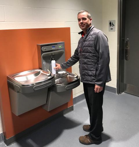 Brian Duke fills up a refillable water bottle at a new water filling station on campus.