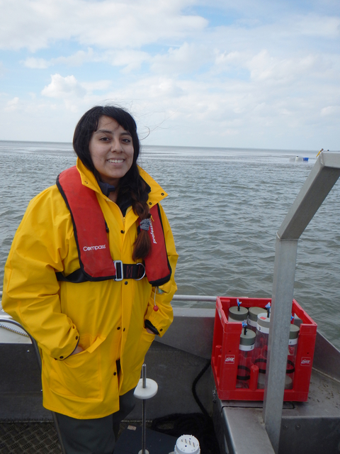 Paulina Huanca in a yellow raincoat on a research boat