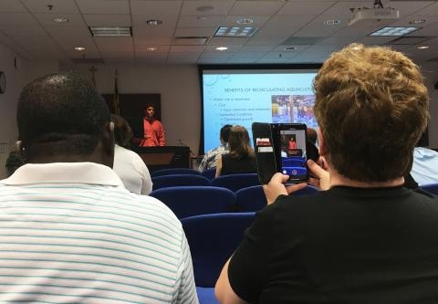 parents take a photo of their child who is presenting their research