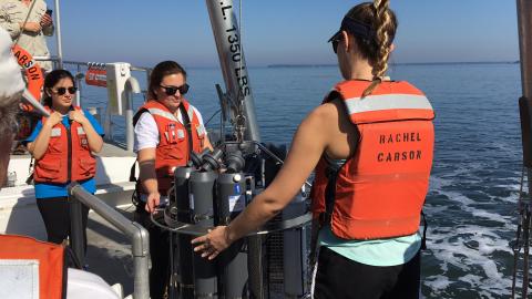 Students ready the CTD rosette, a device that measures conductivity, temperature, and depth, to be lowered into the water.