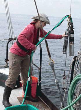 Laura Lapham recovers equipment that she and colleagues lowered into the Bay to collect water samples at different depths.