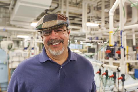 Scientist Al Place poses inside his lab's aquaculture facility.