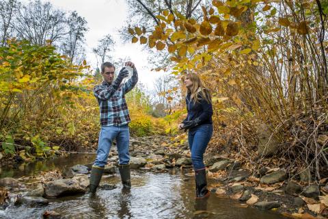 two people testing water in a stream