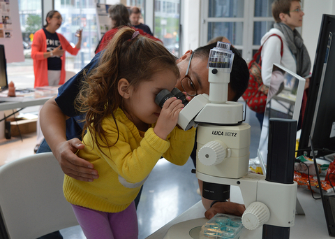 A child looks into a microscope at IMET's Open House