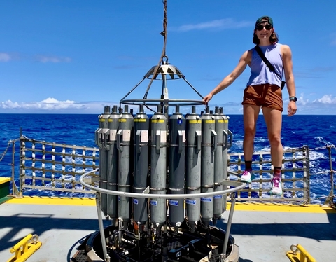 Maddy Lahm stands on top of at CTE, a piece of scientific equipment, on a research vessel