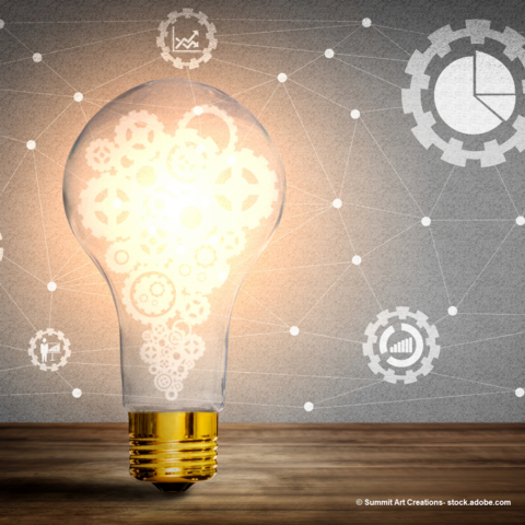 glowing lighbulb resting on wooden table with diagrams and mechanical gears floating from the bulb. Background is purple to offset glow of bulb. 
