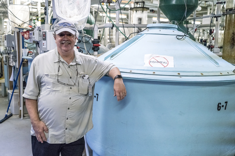 Al Place Stands next to an aquaculture tank at IMET