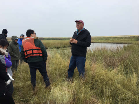 Jeff Cornwell Speaking to students on Poplar Island among marsh grass