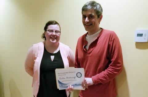 Tsetso Bachvaroff poses with the certificate he received from Kaila Noland and the other graduate students. 